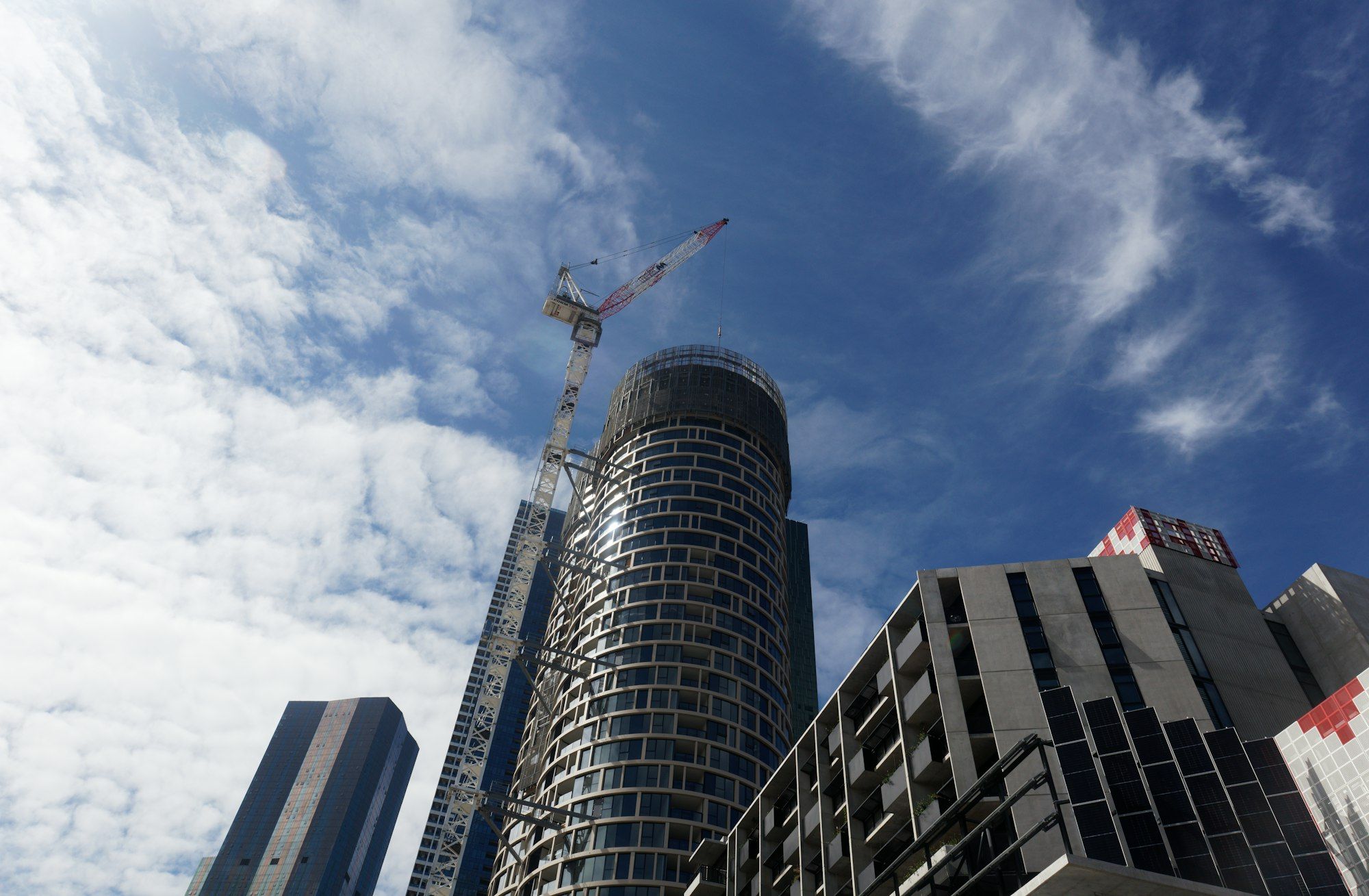 A tower crane on top of a residential high-rise under construction in Melbourne