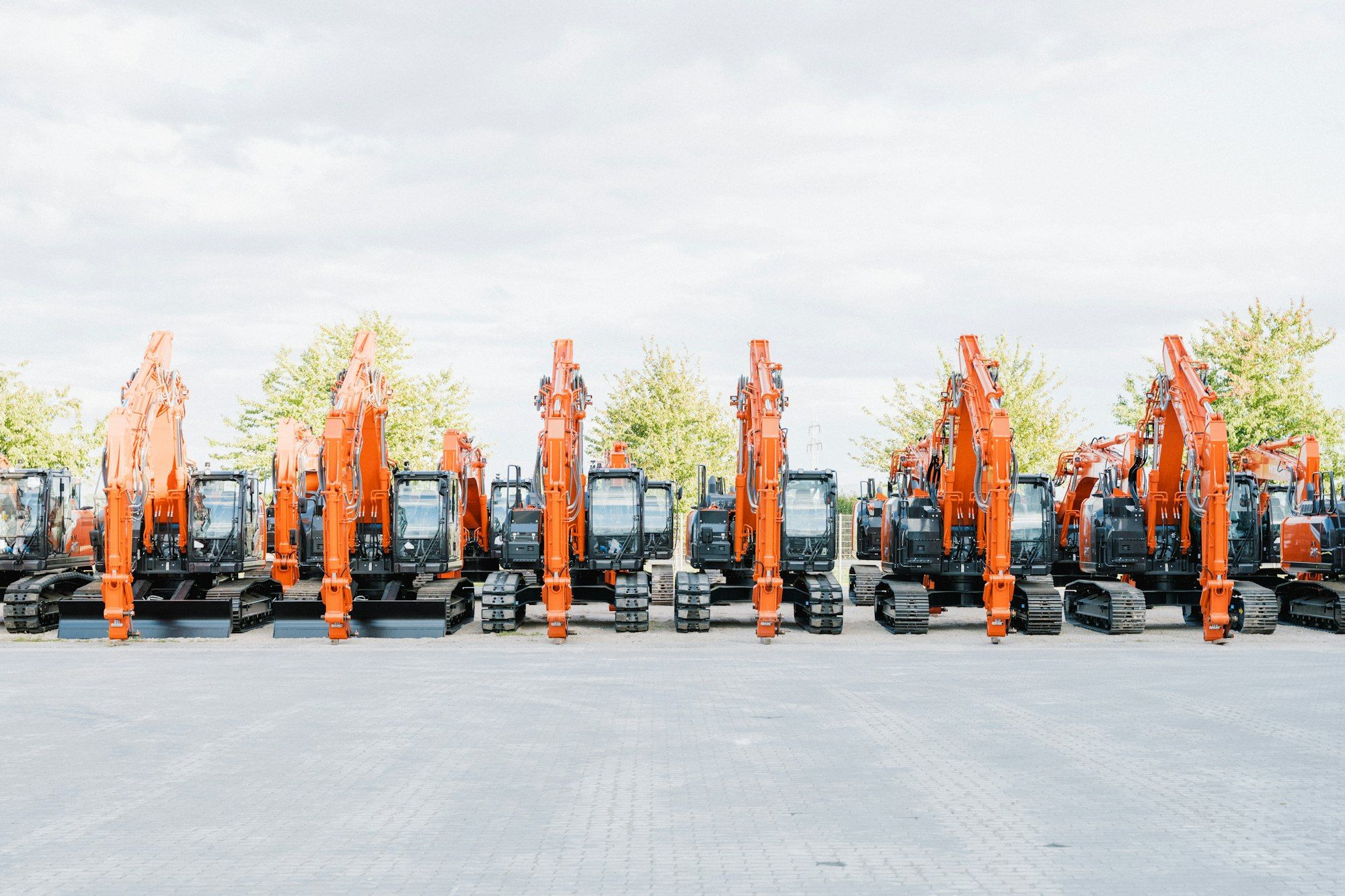 Rows of excavators and earthmoving machinery lined up in an equipment sales yard