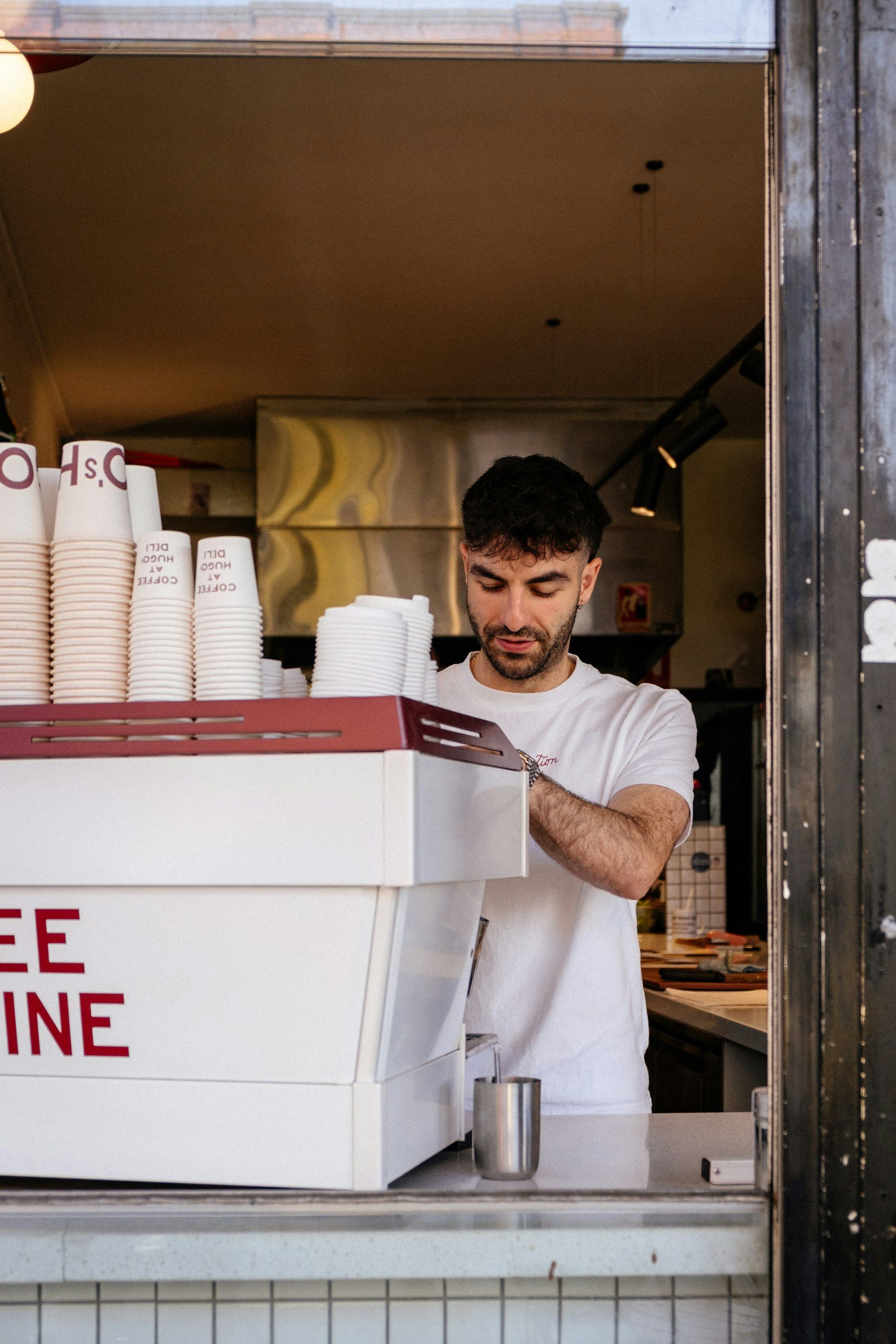 A barista making coffee at the espresso machine behind a Melbourne cafe counter